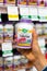 Shoppers hand holding a plastic bottle of Nature`s Way Valerian vegetarian capsules