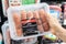 Shoppers hand holding a Plastic package of hot pork italian sausages