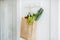 Shopping bag full of fresh vegetables hanging indoors
