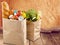 Shopping bags with grocery products on wooden