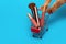 Shopping basket with female cosmetics on a blue background, cat`s legs pushing a trolley