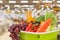 Shopping basket filled with fruits and vegetables with supermarket grocery store blurred defocused background