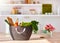 a shopping basket on sunlit kitchen countertop  full of tasty fresh food