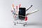 Shopping cart with digital glucometer, lancet pen and syringes on light background. Diabetes concept