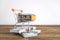 Shopping cart full of coins stands on dollars of a bundle of banknotes on a white background.