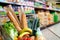 Shopping cart full of food in supermarket aisle elevated view