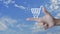 Shopping cart icon on finger over blue sky with whie clouds, Business shop online concept