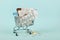 Shopping cart loaded with pills on a blue background. The concept of medicine and the sale of drugs. Copy space