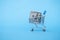 shopping cart with one hundred dollar banknote on blue background Buying currency. Currency exchange. World financial