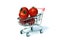 Shopping cart with red ripe tomatoes on white background