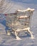 Shopping cart from the supermarket in the snow. The concept of closed stores, low demand, crisis, corontin. Consumer winter