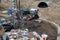 Shopping carts filled with trash and recylables are adjacent to debris and a homeless camp at 8100 Haskell Ave