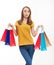 Shopping concept.Beautiful young woman with shopping bags and casual style. Jeans and yellow shirt. Mock up and copy space.