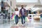 Shopping Concept. Happy Black Couple Walking In Mall Carrying Colorful Shopper Bags