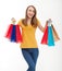 Shopping concept.Smiling beautiful young woman with shopping bags and casual style.Jeans and yellow shirt. Mock up and copy space.