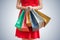 Shopping concept. Woman in red dress holds many colorful bags