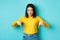 Shopping concept. Young teenage korean girl pointing and looking down at commercial, standing against blue background