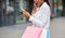 Shopping discount or final sale. Shocked african american young woman covers her mouth with hand and looks at smartphone