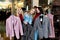 Shopping, fashion and friendship-three smiling friends choose a business suit in a clothing store and pose for the