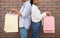 Shopping and gifts. African american couple in casual with multicolored bags stand back to each other