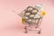 Shopping grocery cart with medicament, tablet, spray, thermometer on pink background. Concept of healthy care, business, shopping