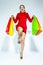 Shopping Ideas and Concepts. Portrait of Jumping Caucasian Girl  Posing With Plenty of Colorful Shopping Bags Against White