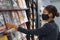 Shopping indoors during coronavirus pandemic. Asian woman wearing face mask while at public library or buying reading