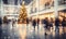 A shopping mall decorated for christmas with a large illuminated Christmas tree and busy shoppers