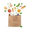 Shopping paper bag with fresh vegetables falling into it - potato, carrot, cucumber, onion, pepper, tomato, aubergine, eggplant,