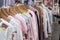 A shopping rank filled with clothes, pajamas and robes. Bunch of clothes of different colors for sale.