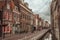 Shopping street with canal, brick buildings and bicycles on cloudy day in Delft.