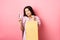 Shopping. Stylish asian girl showing shop bag and plastic credit card, standing on pink background