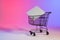 Shopping trolley with blank canvas and copy space over neon purple background