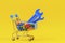 Shopping trolley cart with blue wrenches tools and full of colorful bolts an on yellow background