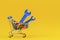 Shopping trolley cart with blue wrenches tools and full of colorful bolts an on yellow background