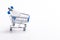 Shopping Trolley Cart with White Traditional Electric Lightbulb As Concept of Saving Energy Placed Over Pure White Background