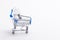 Shopping Trolley Cart with White Traditional Electric Lightbulb As Concept of Saving Energy Placed Over Pure White Background