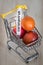 A shopping trolley with a Coronavirus vial and easter eggs. The concept of the impact of the virus on trade and the economy