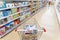 A shopping trolley stands in the department of children`s toys in a supermarket