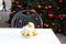 Shopping village cafe. Coffee cup with golden Christmas balls inside and around. Coffee pair on white table angle, grey