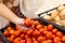 Shopping. Woman choosing bio food fruit tomato in vegetable store or supermarket.A hand woman holding red tomatoes, select between