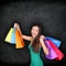 Shopping woman holding shopping bags on blackboard