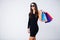 Shopping. Women holding colored bags on ligth background in black friday holiday