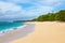 Shore of an azure, turquoise, blue lagoon. Waves, surf, swash at a remote empty idyllic sandy beach on Foa island, Haapai, Tonga.