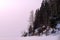 Shore of a frozen pond on the background of a setting frosty haze