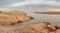 The shore of the Krasnoyarsk reservoir without water, sandy ripples, clay and hills