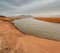 The shore of the Krasnoyarsk reservoir without water, sandy ripples, clay and hills