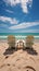 Shoreline relaxation Beach chairs on white sand under sunny blue skies