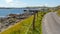 Shoreline road between fences with spectacular coastal scenery