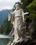 On the shores of a serene lake, a statue of Jesus stands as a beacon of hope and faith, overlooking the tranquil waters